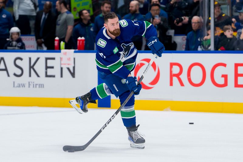 Mar 13, 2024; Vancouver, British Columbia, CAN; Vancouver Canucks defenseman Filip Hronek (17) shoots during warm up prior to a game against the Colorado Avalanche at Rogers Arena. Mandatory Credit: Bob Frid-USA TODAY Sports