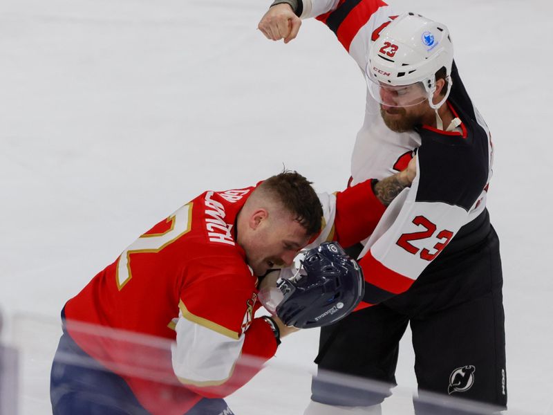 Nov 14, 2024; Sunrise, Florida, USA; New Jersey Devils left wing Kurtis MacDermid (23) and Florida Panthers left wing Jonah Gadjovich (12) fight during the third period at Amerant Bank Arena. Mandatory Credit: Sam Navarro-Imagn Images