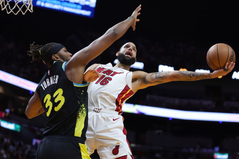 MIAMI, FLORIDA - DECEMBER 02: Caleb Martin #16 of the Miami Heat drives against Myles Turner #33 of the Indiana Pacers during the first quarter of the game at Kaseya Center on December 02, 2023 in Miami, Florida. NOTE TO USER: User expressly acknowledges and agrees that, by downloading and or using this photograph, User is consenting to the terms and conditions of the Getty Images License Agreement. (Photo by Megan Briggs/Getty Images)