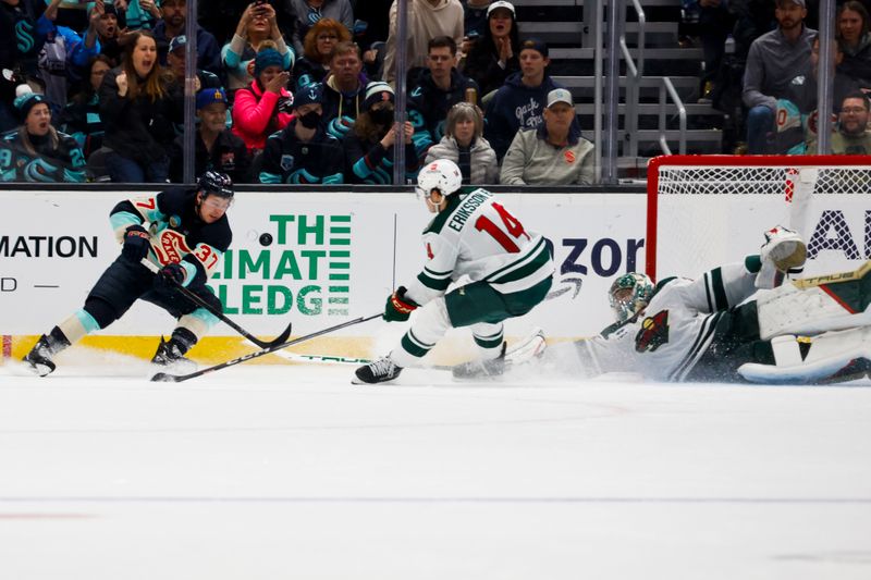 Feb 24, 2024; Seattle, Washington, USA; Minnesota Wild center Joel Eriksson Ek (14) pokes away a shot by Seattle Kraken center Yanni Gourde (37) as goaltender Marc-Andre Fleury (29) dives across the net during the second period at Climate Pledge Arena. Mandatory Credit: Joe Nicholson-USA TODAY Sports