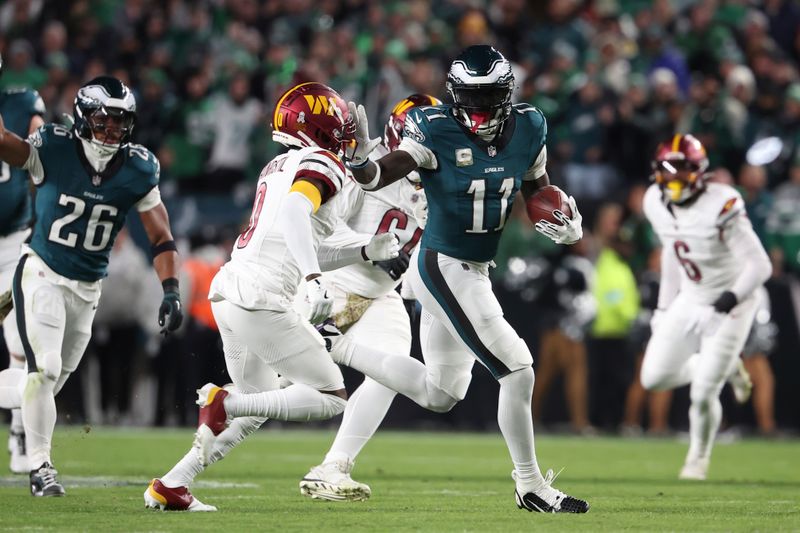 Philadelphia Eagles wide receiver A.J. Brown (11) tries to stiff arm a defender as he runs after a catch during an NFL football game against the Washington Commanders, Thursday, Nov. 14, 2024, in Philadelphia, PA. (AP Photo/Peter Joneleit)