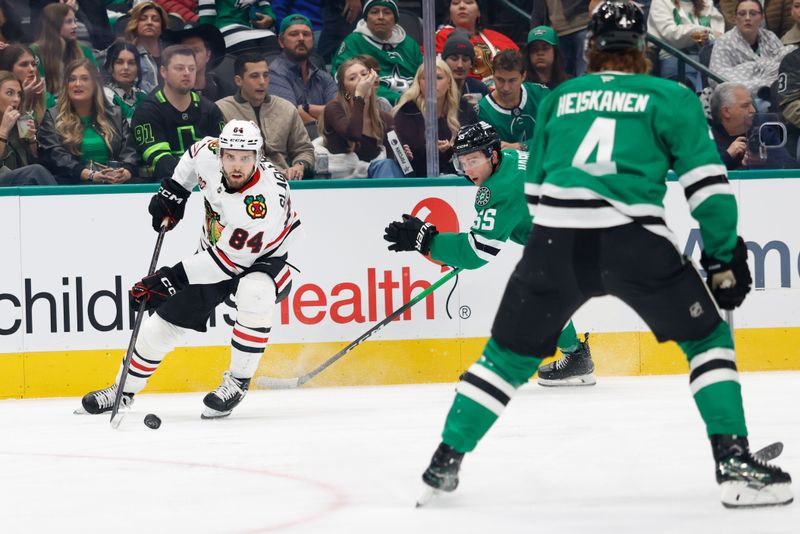 Dec 27, 2025; Dallas, Texas, USA;  Chicago Blackhawks left wing Landon Slaggert (84) skates with the puck against Dallas Stars defenseman Thomas Harley (55) during the first period at American Airlines Center. Mandatory Credit: Chris Jones-Imagn Images