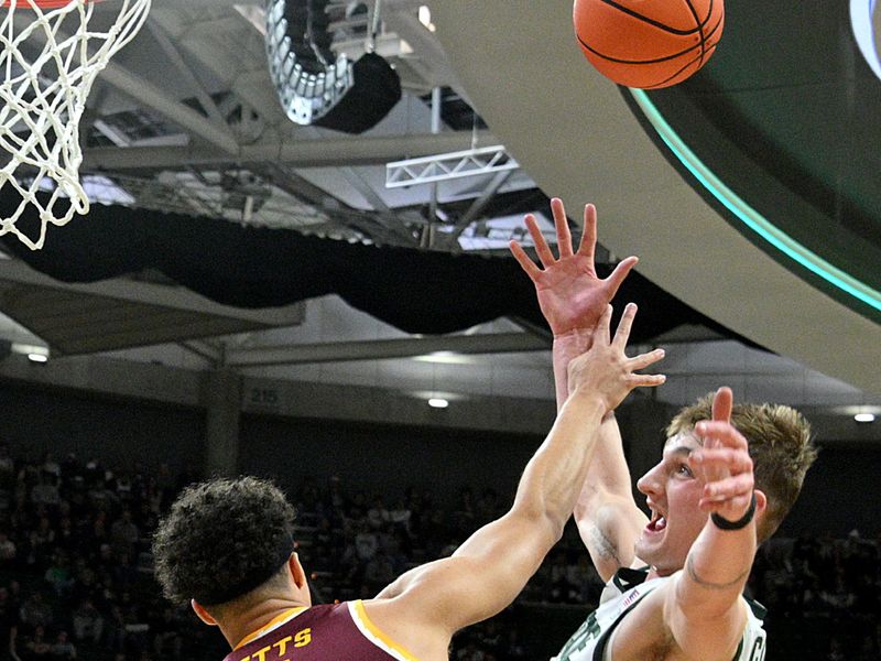 Jan 28, 2025; East Lansing, Michigan, USA;  Minnesota Golden Gophers forward Kadyn Betts (4) fouls Michigan State Spartans center Carson Cooper (15) during the second half at Jack Breslin Student Events Center. Mandatory Credit: Dale Young-Imagn Images