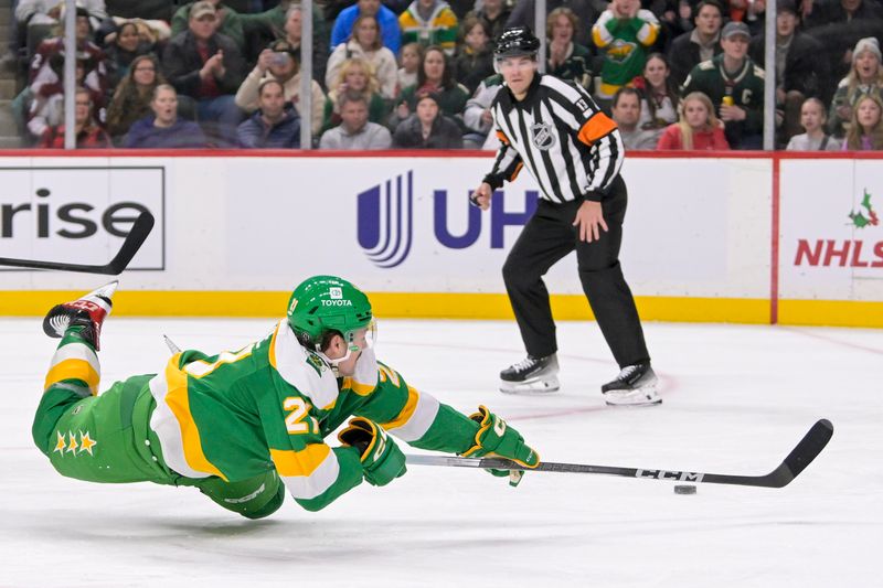 Nov 24, 2023; Saint Paul, Minnesota, USA; Minnesota Wild forward Brandon Duhaime (21) gets a shot off as he losses his footing against the Colorado Avalanche during the second period at Xcel Energy Center. Mandatory Credit: Nick Wosika-USA TODAY Sports