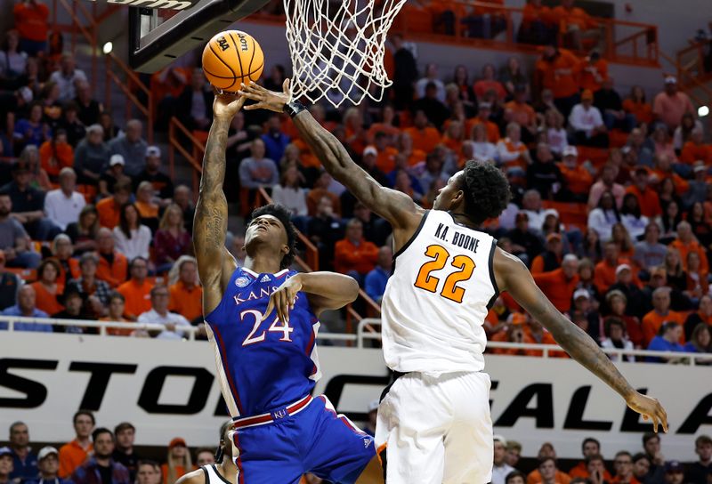 Feb 14, 2023; Stillwater, Oklahoma, USA; Kansas Jayhawks forward K.J. Adams Jr. (24) goes up for a basket as Oklahoma State Cowboys forward Kalib Boone (22) defends the basket during the second half at Gallagher-Iba Arena. Kansas won 87-76. Mandatory Credit: Alonzo Adams-USA TODAY Sports