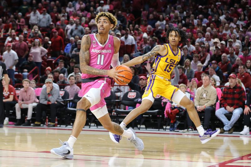 Jan 24, 2023; Fayetteville, Arkansas, USA; Arkansas Razorbacks forward Jalen Graham (11) dribbles past LSU Tigers forward Tyrell Ward (15) during the first half at Bud Walton Arena. Mandatory Credit: Nelson Chenault-USA TODAY Sports