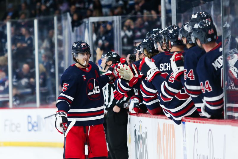 Nov 18, 2023; Winnipeg, Manitoba, CAN; Winnipeg Jets forward Mark Scheifele (55) is congratulated by his team mates on his goal against the Arizona Coyotes during the first period at Canada Life Centre. Mandatory Credit: Terrence Lee-USA TODAY Sports