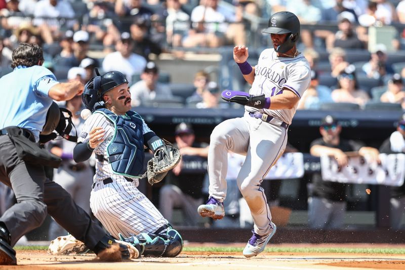 Aug 24, 2024; Bronx, New York, USA;  New York Yankees catcher Austin Wells (28) is unable to hold onto the ball allowing Colorado Rockies shortstop Ezequiel Tovar (14) to score in the first inning at Yankee Stadium. Mandatory Credit: Wendell Cruz-USA TODAY Sports