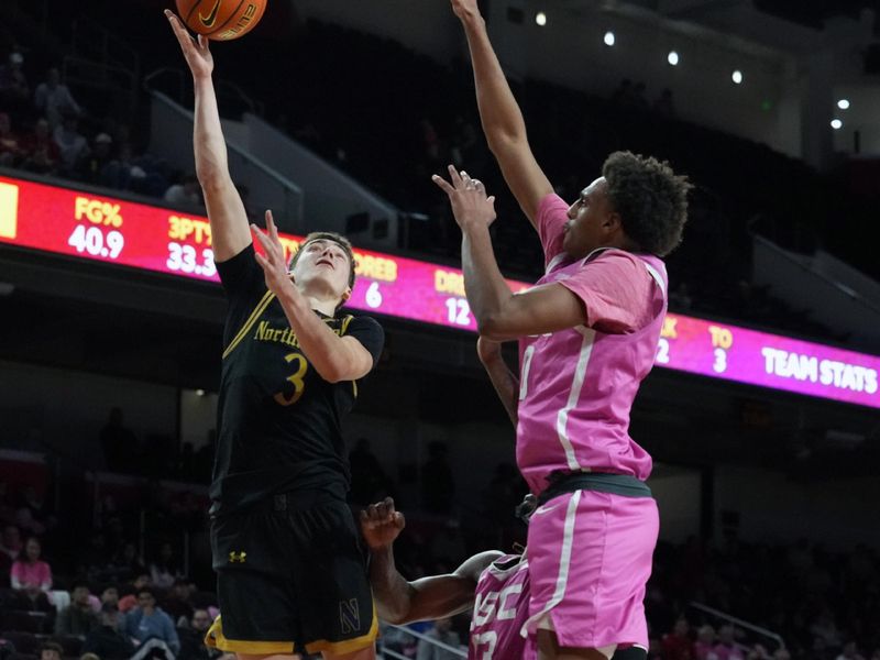 Jan 21, 2026; Los Angeles, California, USA; Northwestern Wildcats guard Jake West (3) shoots the ball against Southern California Trojans guard Alijah Arenas (0) in the first half at Galen Center. Mandatory Credit: Kirby Lee-Imagn Images