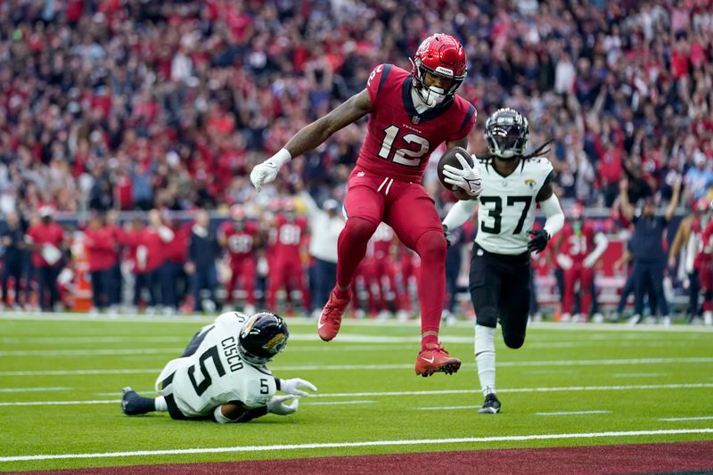 Houston Texans wide receiver Nico Collins (12) leaps past Jacksonville Jaguars safety Andre Cisco (5) to score a touchdown as the Jaguars' Tre Herndon (37) looks on in the second half of an NFL football game in Houston, Sunday, Nov. 26, 2023. (AP Photo/Eric Gay)