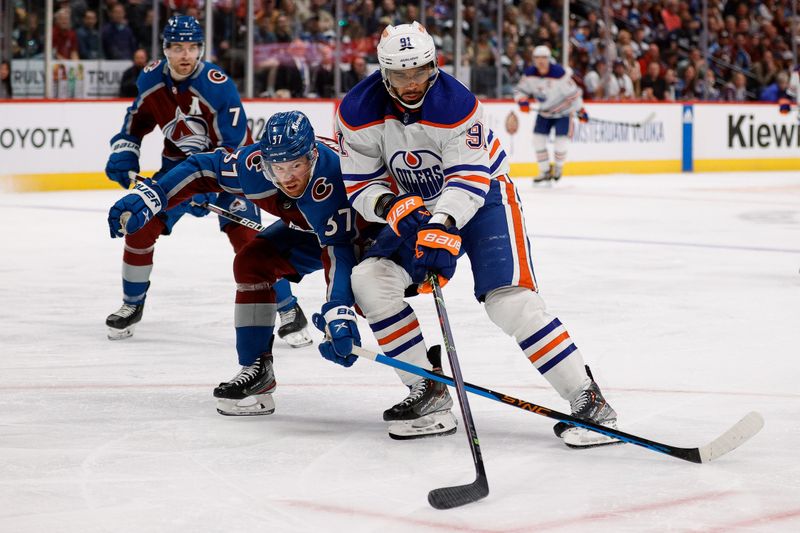 Apr 11, 2023; Denver, Colorado, USA; Edmonton Oilers left wing Evander Kane (91) controls the puck under pressure from Colorado Avalanche left wing J.T. Compher (37) in the third period at Ball Arena. Mandatory Credit: Isaiah J. Downing-USA TODAY Sports