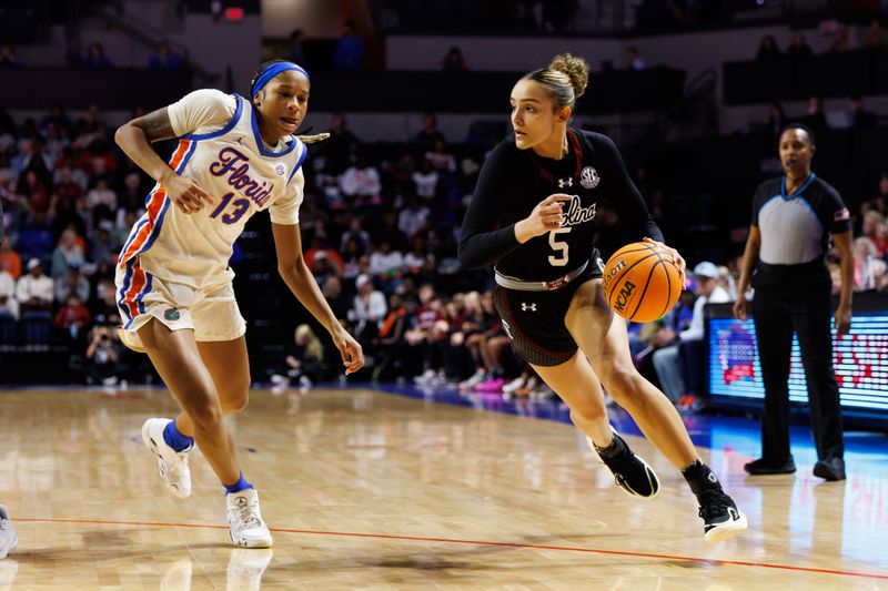 Jan 4, 2026; Gainesville, Florida, USA; South Carolina Gamecocks guard Tessa Johnson (5) drives to the basket past Florida Gators guard Laila Reynolds (13) during the first half at Exactech Arena at the Stephen C. O'Connell Center. Mandatory Credit: Matt Pendleton-Imagn Images