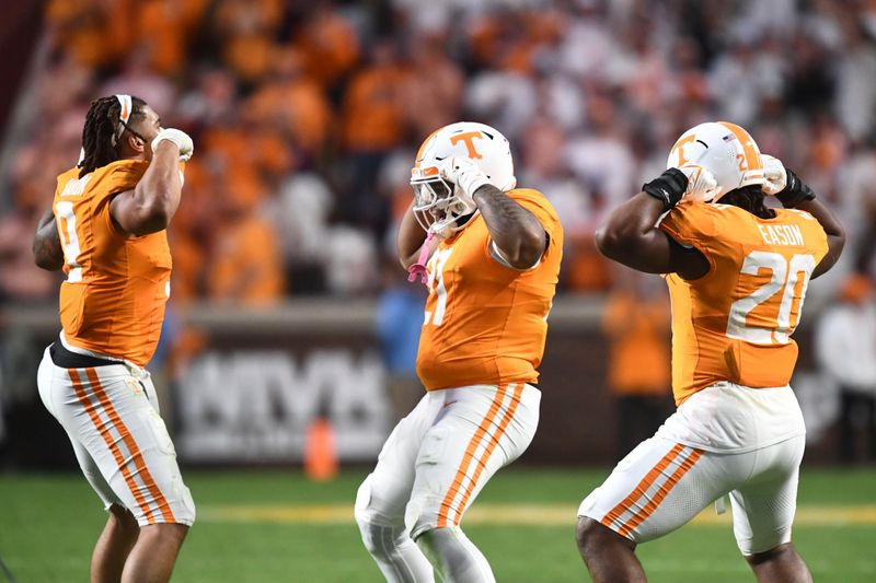 Oct 14, 2023; Knoxville, TN, USA; From left, Tennessee defensive linemen Tyler Baron (9), Omari Thomas (21), and Bryson Eason (20) celebrate in the final moments of the NCAA college football game win over Texas A&M on Saturday, October 14, 2023 in Knoxville, Tenn. Mandatory Credit: Saul Young-USA TODAY Sports