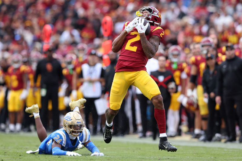 Nov 18, 2023; Los Angeles, California, USA; USC Trojans wide receiver Brenden Rice (2) catches a touchdown against UCLA Bruins defensive back Jaylin Davies (24) during the second quarter at United Airlines Field at Los Angeles Memorial Coliseum. Mandatory Credit: Jason Parkhurst-USA TODAY Sports