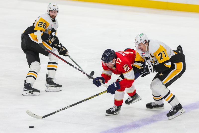 Dec 8, 2023; Sunrise, Florida, USA; Florida Panthers center Evan Rodrigues (17) moves the puck past Pittsburgh Penguins right wing Bryan Rust (17) during the third period at Amerant Bank Arena. Mandatory Credit: Sam Navarro-USA TODAY Sports