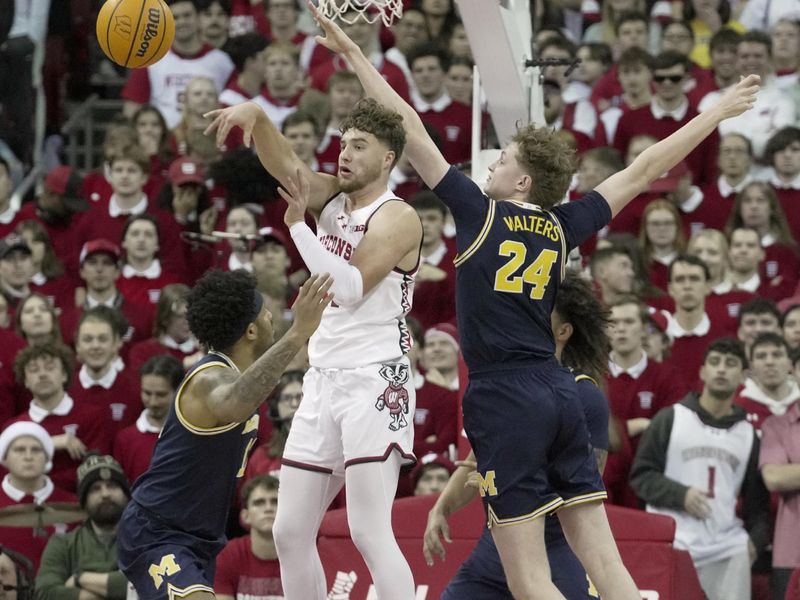 Dec 3, 2024; Madison, Wisconsin, USA; Wisconsin guard Max Klesmit (11) makes a pass while being guarded by Michigan's Sam Walters (24) during the first half of their game Tuesday, December 3, 2024 at the Kohl Center in Madison, Wisconsin.  Mandatory Credit: Mark Hoffman/USA TODAY Network via Imagn Images 