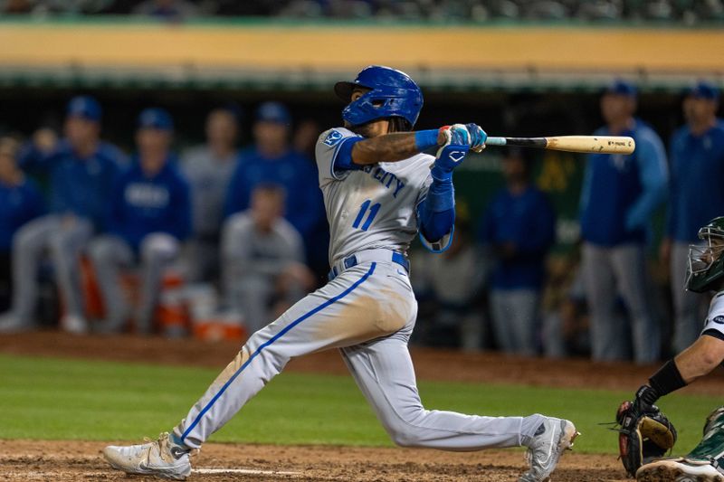 Aug 21, 2023; Oakland, California, USA;  Kansas City Royals third baseman Maikel Garcia (11) hits a RBI sacrifice fly against the Oakland Athletics during the eighth inning at Oakland-Alameda County Coliseum. Mandatory Credit: Neville E. Guard-USA TODAY Sports