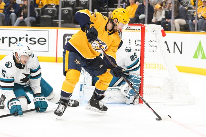 Oct 21, 2023; Nashville, Tennessee, USA; Nashville Predators center Tommy Novak (82) takes a shot on goal against the San Jose Sharks during the third period at Bridgestone Arena. Mandatory Credit: Steve Roberts-USA TODAY Sports