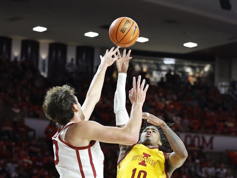 Jan 6, 2024; Norman, Oklahoma, USA; Iowa State Cyclones guard Keshon Gilbert (10) shoots as Oklahoma Sooners forward Sam Godwin (10) defends during the first half at Lloyd Noble Center. Mandatory Credit: Alonzo Adams-USA TODAY Sports