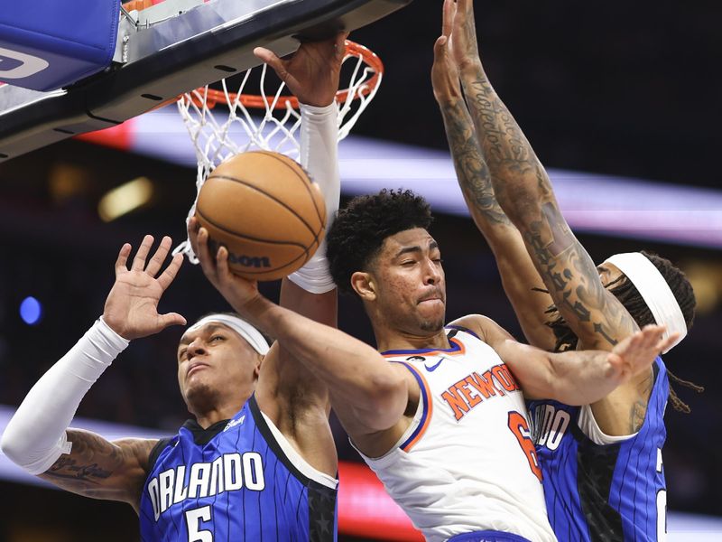 ORLANDO, FLORIDA - MARCH 23: Quentin Grimes #6 of the New York Knicks looks to pass the ball against Paolo Banchero #5 and Markelle Fultz #20 of the Orlando Magic in the first quarter at Amway Center on March 23, 2023 in Orlando, Florida. NOTE TO USER: User expressly acknowledges and agrees that, by downloading and or using this photograph, User is consenting to the terms and conditions of the Getty Images License Agreement. (Photo by Douglas P. DeFelice/Getty Images)