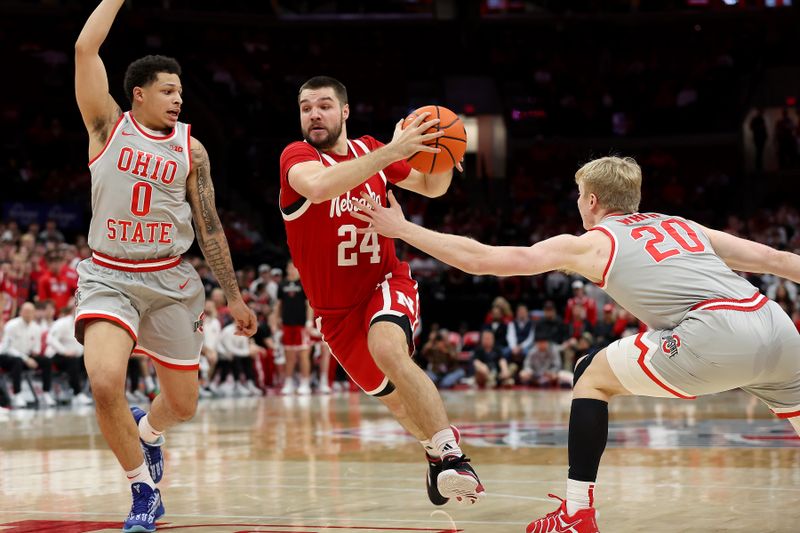 Mar 4, 2025; Columbus, Ohio, USA;  Nebraska Cornhuskers guard Rollie Worster (24) drives to the basket as Ohio State Buckeyes guard John Mobley Jr. (0) and Ohio State Buckeyes forward Colin White (20) defend during the first half at Value City Arena. Mandatory Credit: Joseph Maiorana-Imagn Images
