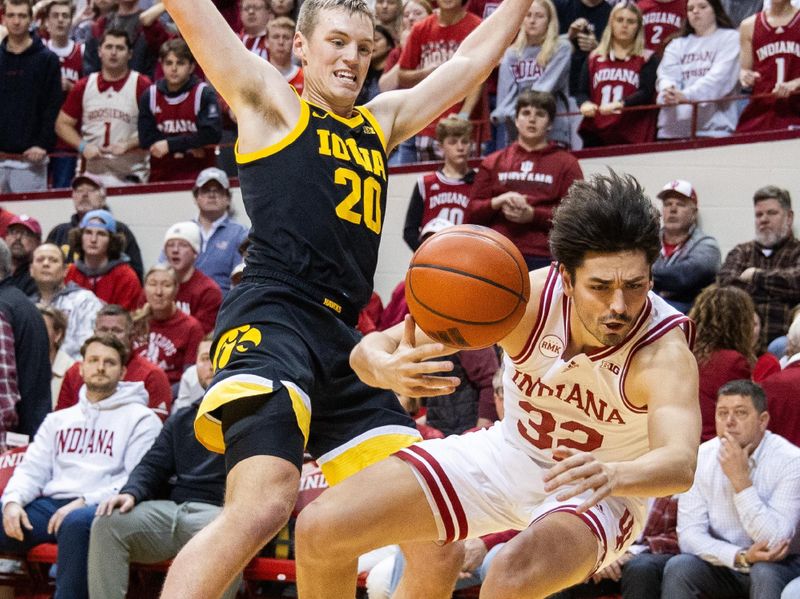 Jan 30, 2024; Bloomington, Indiana, USA; Indiana Hoosiers guard Trey Galloway (32) is fouled by Iowa Hawkeyes forward Payton Sandfort (20) in the first half at Simon Skjodt Assembly Hall. Mandatory Credit: Trevor Ruszkowski-USA TODAY Sports