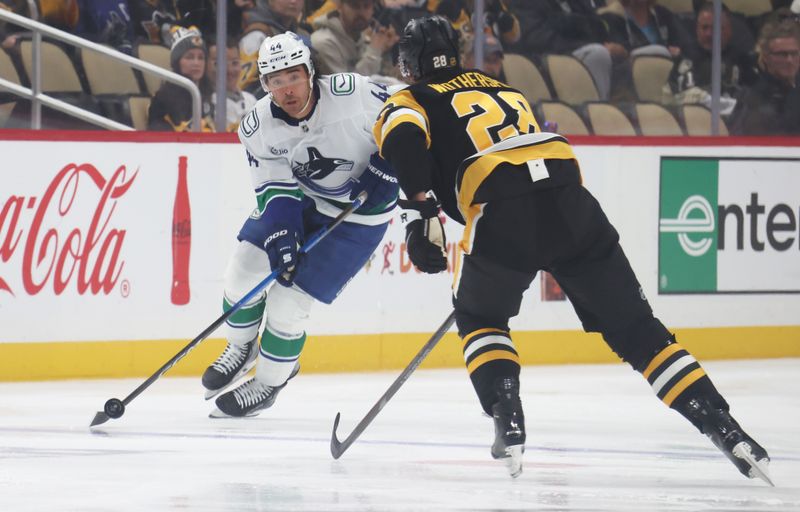 Oct 21, 2025; Pittsburgh, Pennsylvania, USA;  Vancouver Canucks left wing Kiefer Sherwood (44) carries the puck up ice against Pittsburgh Penguins defenseman Parker Wotherspoon (28) during the first period at PPG Paints Arena. Mandatory Credit: Charles LeClaire-Imagn Images