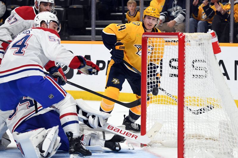 Mar 5, 2024; Nashville, Tennessee, USA; Nashville Predators center Gustav Nyquist (14) watches as the puck flies through the crease against Montreal Canadiens goaltender Jake Allen (34) during the first period at Bridgestone Arena. Mandatory Credit: Christopher Hanewinckel-USA TODAY Sports