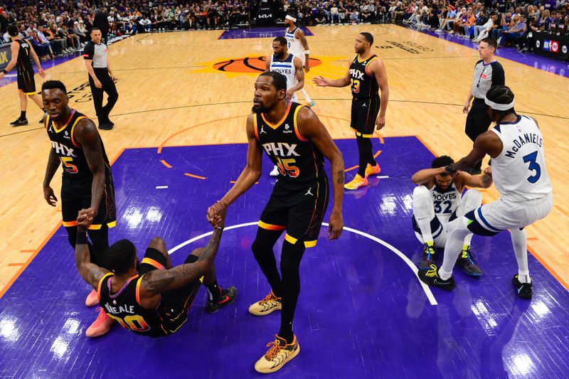 PHOENIX, AZ - APRIL  28: Royce O'Neale #00 of the Phoenix Suns is helped up by teammates Nassir Little #25 and Kevin Durant #35 and Karl-Anthony Towns #32 of the Minnesota Timberwolves is helped up by teammate Jaden McDaniels #3 during the game during Round 1 Game 4 of the 2024 NBA Playoffs on April 28, 2024 at Footprint Center in Phoenix, Arizona. NOTE TO USER: User expressly acknowledges and agrees that, by downloading and or using this photograph, user is consenting to the terms and conditions of the Getty Images License Agreement. Mandatory Copyright Notice: Copyright 2024 NBAE (Photo by Kate Frese/NBAE via Getty Images)