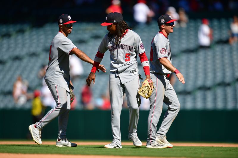 Jun 29, 2025; Anaheim, California, USA; Washington Nationals right fielder Daylen Lile (51) shortstop CJ Abrams (5) and center fielder Jacob Young (30) celebrate the victory against the Los Angeles Angels at Angel Stadium. Mandatory Credit: Gary A. Vasquez-Imagn Images