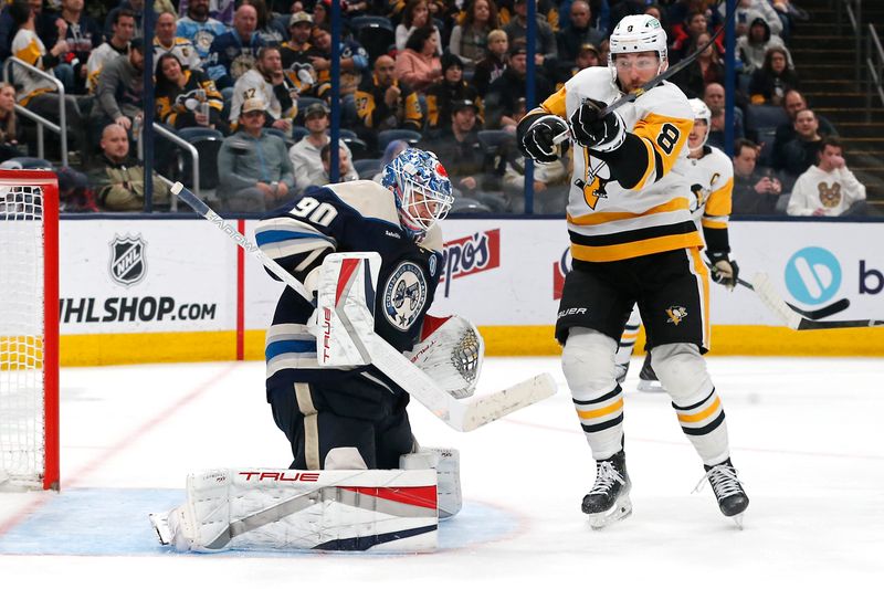 Nov 15, 2024; Columbus, Ohio, USA; Pittsburgh Penguins left wing Michael Bunting (8) tips the puck over Columbus Blue Jackets goalie Elvis Merzlikins (90) during the third period at Nationwide Arena. Mandatory Credit: Russell LaBounty-Imagn Images