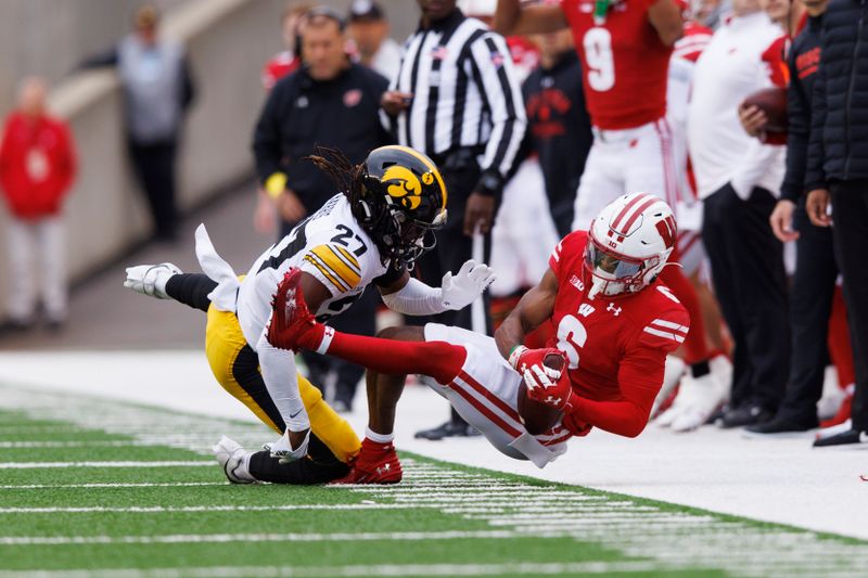 Oct 14, 2023; Madison, Wisconsin, USA;  Iowa Hawkeyes defensive back Jermari Harris (27) breaks up the pass intended for Wisconsin Badgers wide receiver Will Pauling (6) during the second quarter at Camp Randall Stadium. Mandatory Credit: Jeff Hanisch-USA TODAY Sports