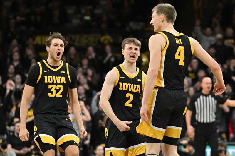 Feb 17, 2024; Iowa City, Iowa, USA; Iowa Hawkeyes forward Owen Freeman (32) and guard Brock Harding (2) and guard Josh Dix (4) react during the first half against the Wisconsin Badgers at Carver-Hawkeye Arena. Mandatory Credit: Jeffrey Becker-USA TODAY Sports