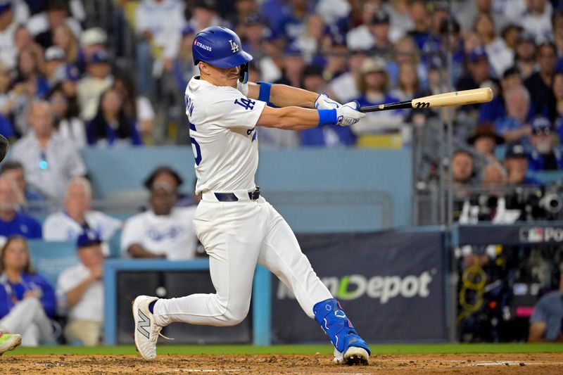 Oct 20, 2024; Los Angeles, California, USA; Los Angeles Dodgers shortstop Tommy Edman (25) hits a two run home run in the third inning against the New York Mets during game six of the NLCS for the 2024 MLB playoffs at Dodger Stadium. Mandatory Credit: Jayne Kamin-Oncea-Imagn Images