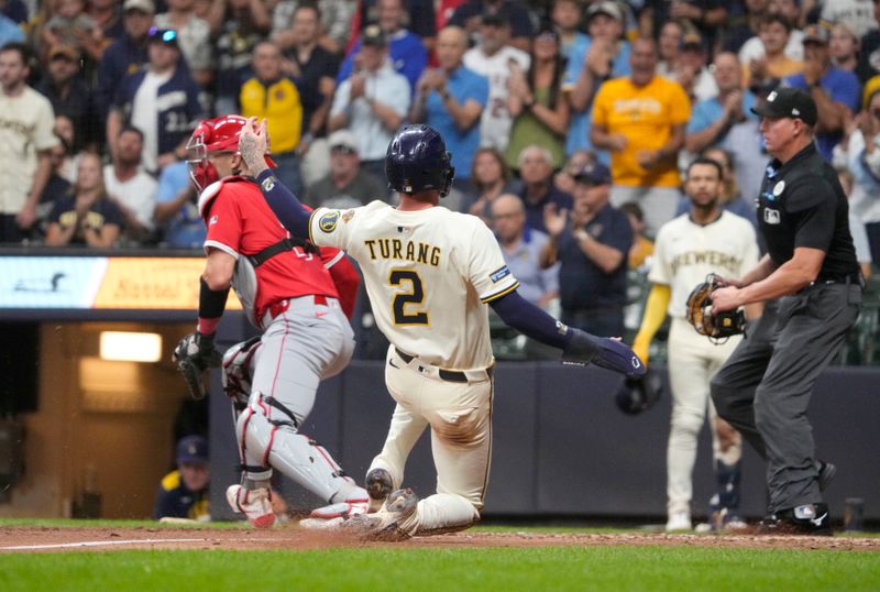 Sep 16, 2025; Milwaukee, Wisconsin, USA: Milwaukee Brewers second base Brice Turang (2) slides into home plate safely against Los Angeles Angels first base Logan O’Hoppe (21)  in the seventh inning at American Family Field. Mandatory Credit: Michael McLoone-Imagn Images