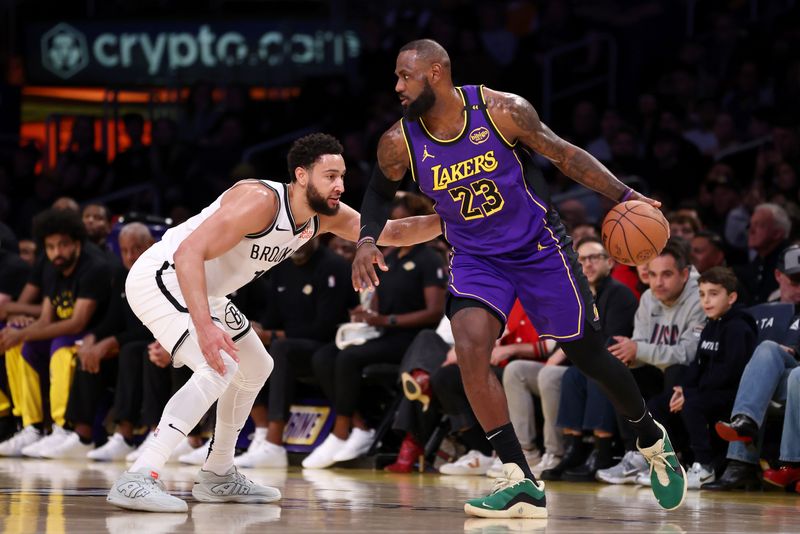 LOS ANGELES, CALIFORNIA - JANUARY 17: LeBron James #23 of the Los Angeles Lakers dribbles the ball against Ben Simmons #10 of the Brooklyn Nets during the first quarter at Crypto.com Arena on January 17, 2025 in Los Angeles, California. NOTE TO USER: User expressly acknowledges and agrees that, by downloading and/or using this Photograph, user is consenting to the terms and conditions of the Getty Images License Agreement. (Photo by Katelyn Mulcahy/Getty Images)