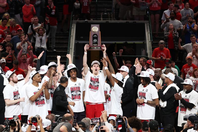 Mar 31, 2024; Dallas, TX, USA; North Carolina State Wolfpack forward Ben Middlebrooks (34) and teammates celebrate with the trophy after defeating the Duke Blue Devils in the finals of the South Regional of the 2024 NCAA Tournament at American Airline Center. Mandatory Credit: Tim Heitman-USA TODAY Sports