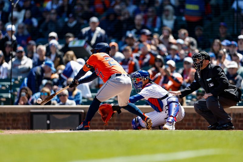 Apr 25, 2024; Chicago, Illinois, USA; Houston Astros second baseman Jose Altuve (27) hits a single against the Chicago Cubs during the first inning at Wrigley Field. Mandatory Credit: Kamil Krzaczynski-USA TODAY Sports