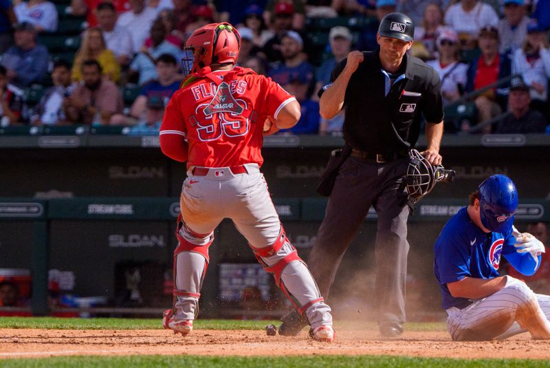 Feb 27, 2025; Mesa, Arizona, USA; Chicago Cubs infielder James Triantos (95) is tagged out at home by Los Angeles Angels catcher Juan Flores (99) in the sixth inning of a spring training game at Sloan Park. Mandatory Credit: Allan Henry-Imagn Images
