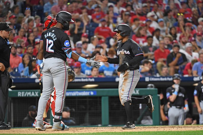 Aug 13, 2024; Philadelphia, Pennsylvania, USA; Miami Marlins shortstop Xavier Edwards (63) celebrates with outfielder Jesús Sánchez (12) afters scoring a run during the seventh inning against the Philadelphia Phillies at Citizens Bank Park. Mandatory Credit: Eric Hartline-USA TODAY Sports