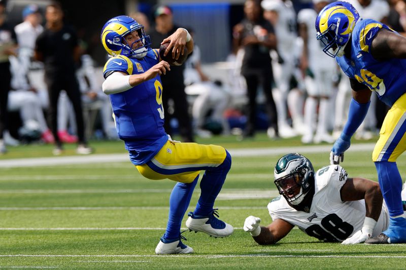 Los Angeles Rams quarterback Matthew Stafford, left, goes down after being tackled by Philadelphia Eagles defensive tackle Jalen Carter, center, during the first half of an NFL football game Sunday, Oct. 8, 2023, in Inglewood, Calif. (AP Photo/Kevork Djansezian)