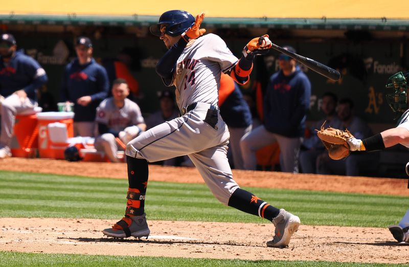 May 25, 2024; Oakland, California, USA; Houston Astros second baseman Mauricio Dubon (14) hits the ball Oakland Athletics during the sixth inning at Oakland-Alameda County Coliseum. Mandatory Credit: Kelley L Cox-USA TODAY Sports