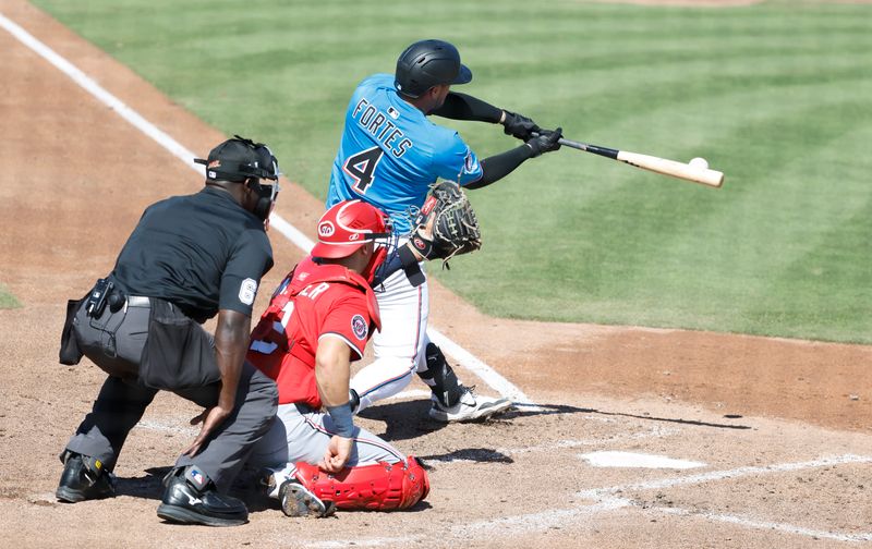 Feb 25, 2025; Jupiter, Florida, USA;  Miami Marlins catcher Nick Fortes (4) singles against the Washington Nationals during the fourth inning at Roger Dean Chevrolet Stadium. Mandatory Credit: Rhona Wise-Imagn Image 