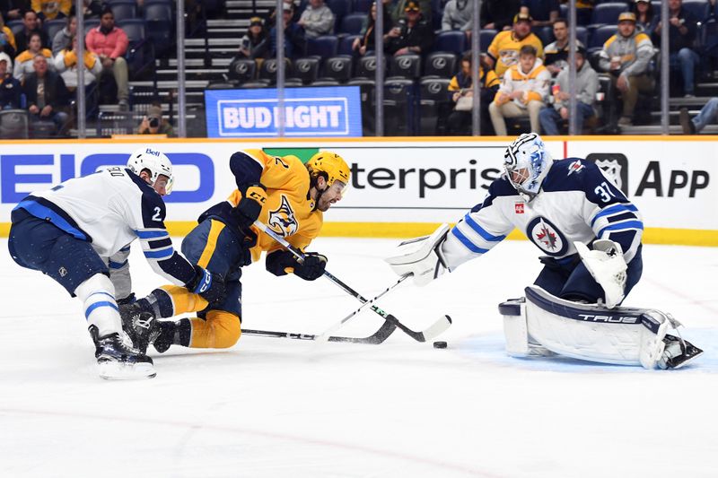 Apr 9, 2024; Nashville, Tennessee, USA; Nashville Predators center Tommy Novak (82) skates past Winnipeg Jets defenseman Dylan DeMelo (2) before scoring against goaltender Connor Hellebuyck (37) during the first period at Bridgestone Arena. Mandatory Credit: Christopher Hanewinckel-USA TODAY Sports