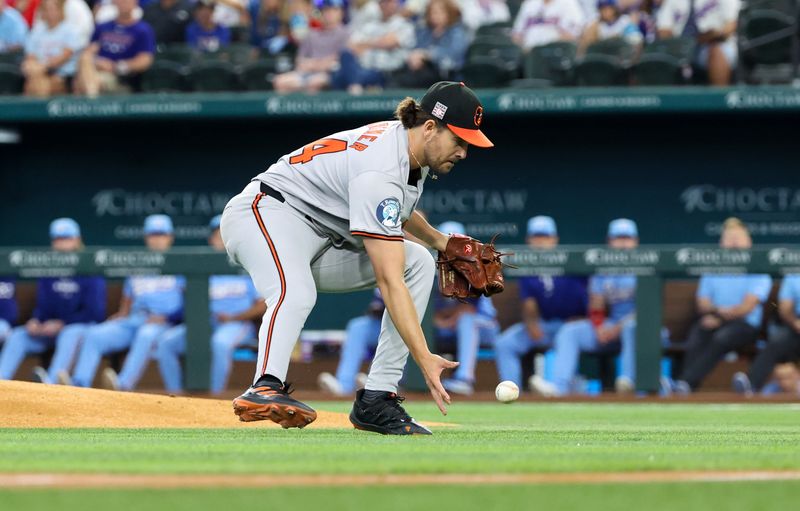 Jul 21, 2024; Arlington, Texas, USA;  Baltimore Orioles starting pitcher Dean Kremer (64) fields a ground ball during the first inning against the Texas Rangers at Globe Life Field. Mandatory Credit: Kevin Jairaj-USA TODAY Sports