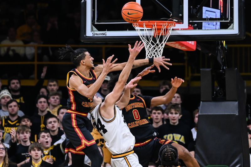 Jan 28, 2026; Iowa City, Iowa, USA; Southern California Trojans forward Chad Baker-Mazara (4) and guard Alijah Arenas (0) defend the shot of Iowa Hawkeyes guard Tate Sage (24) during the first half at Carver-Hawkeye Arena. Mandatory Credit: Jeffrey Becker-Imagn Images