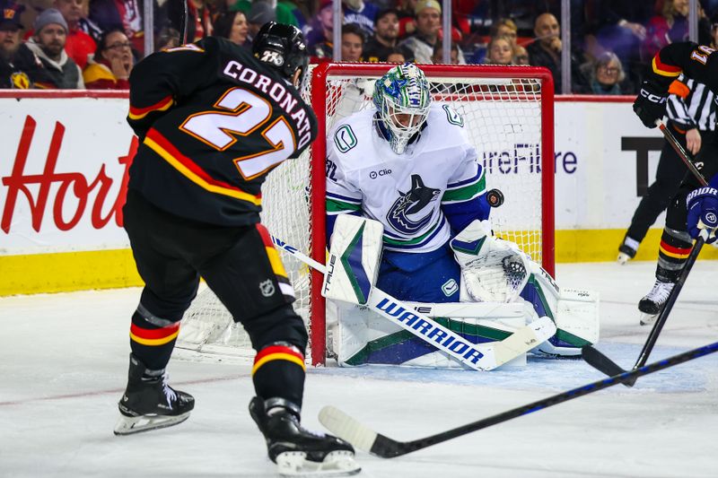 Dec 31, 2024; Calgary, Alberta, CAN; Vancouver Canucks goaltender Kevin Lankinen (32) makes a save against Calgary Flames right wing Matt Coronato (27) during the second period at Scotiabank Saddledome. Mandatory Credit: Sergei Belski-Imagn Images