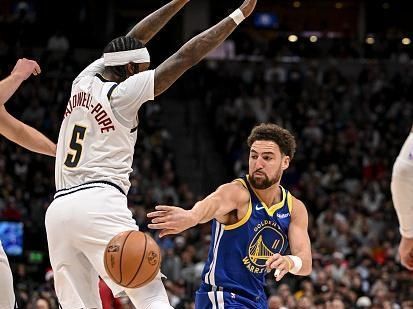 DENVER, CO - DECEMBER 25: Klay Thompson (11) of the Golden State Warriors passes as Kentavious Caldwell-Pope (5) of the Denver Nuggets defends during the first quarter at Ball Arena in Denver on Monday, December 25, 2023. (Photo by AAron Ontiveroz/The Denver Post)