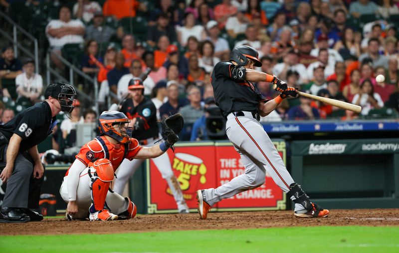 Jun 21, 2024; Houston, Texas, USA; Baltimore Orioles right fielder Anthony Santander (25) hits a two run home run against the Houston Astros in the eighth inning at Minute Maid Park. Mandatory Credit: Thomas Shea-USA TODAY Sports