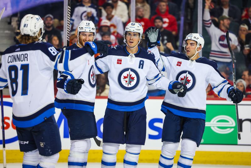 Oct 11, 2023; Calgary, Alberta, CAN; Winnipeg Jets center Mark Scheifele (55) celebrates his goal with teammates against the Calgary Flames during the third period at Scotiabank Saddledome. Mandatory Credit: Sergei Belski-USA TODAY Sports